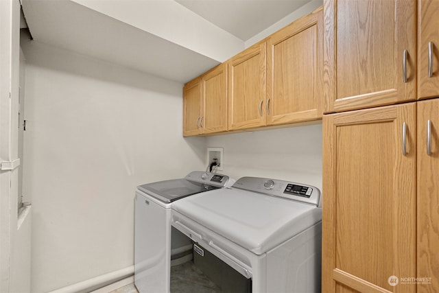 washroom featuring tile patterned floors, washing machine and dryer, and cabinets