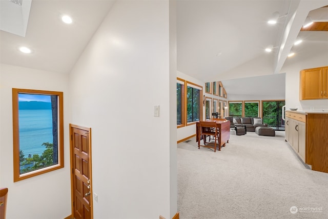 hall with beam ceiling, high vaulted ceiling, and carpet flooring