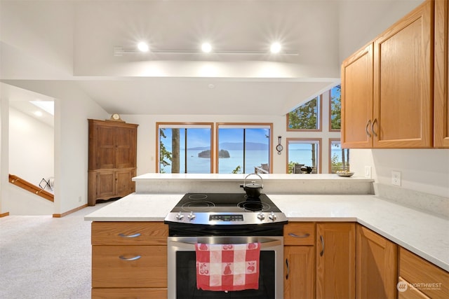 kitchen featuring stainless steel electric stove, vaulted ceiling, light stone countertops, kitchen peninsula, and carpet floors