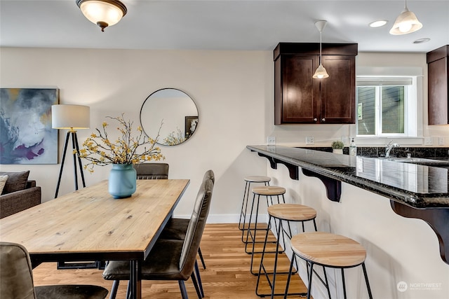 dining space with light wood-type flooring and sink