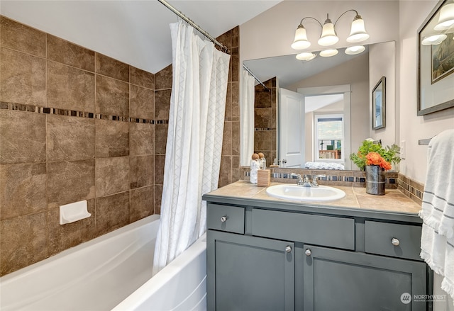 bathroom featuring lofted ceiling, vanity, and shower / tub combo