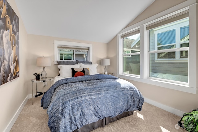 bedroom featuring lofted ceiling, light colored carpet, and multiple windows