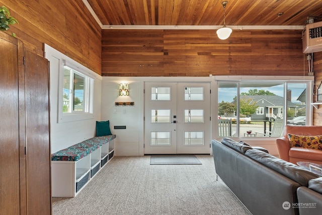 interior space featuring french doors, wood walls, carpet flooring, and wood ceiling