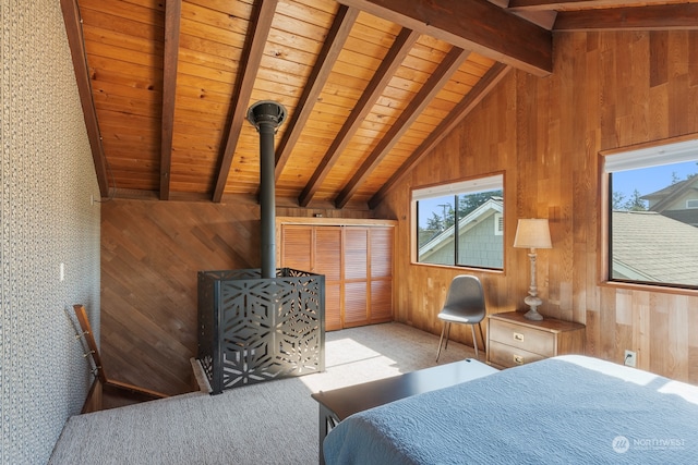 bedroom featuring a wood stove, wood walls, vaulted ceiling with beams, and carpet floors