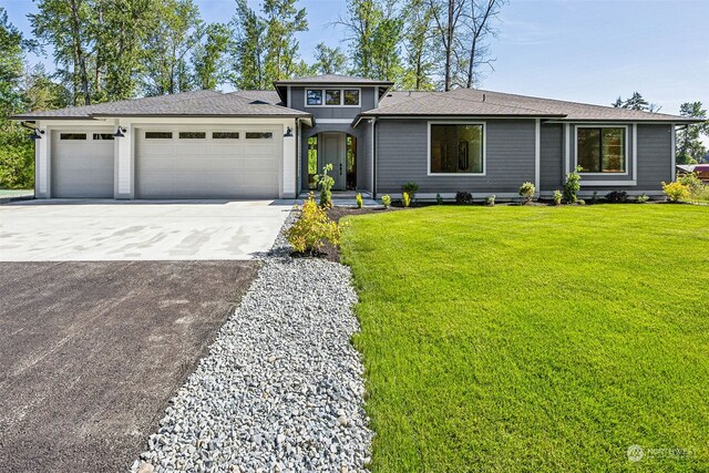 view of front of house featuring a garage and a front lawn