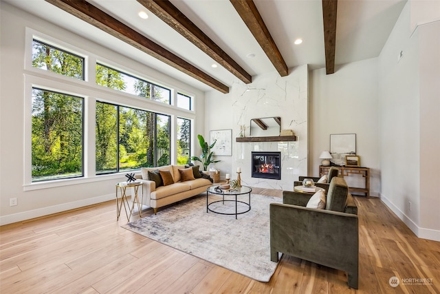 living room with beamed ceiling and light hardwood / wood-style flooring