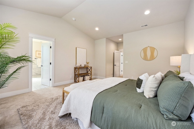 carpeted bedroom with ensuite bath and lofted ceiling