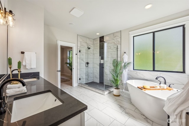 bathroom featuring a freestanding tub, marble finish floor, recessed lighting, a shower stall, and vanity