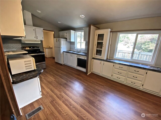 kitchen featuring dishwashing machine, a sink, visible vents, freestanding refrigerator, and stainless steel range with electric stovetop