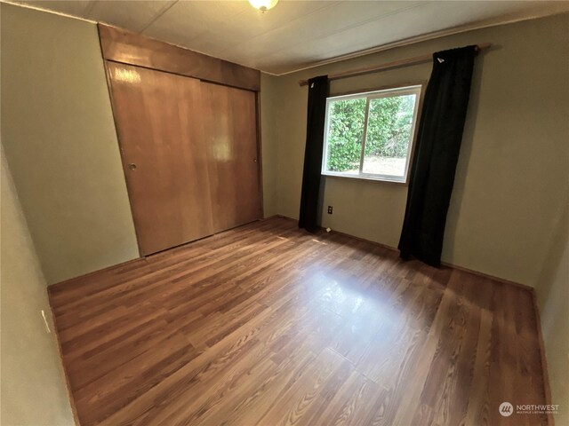 unfurnished bedroom with a closet and wood finished floors