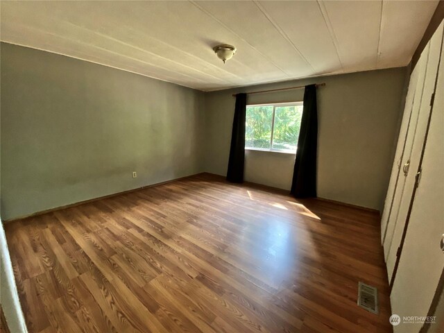 unfurnished bedroom featuring visible vents and wood finished floors