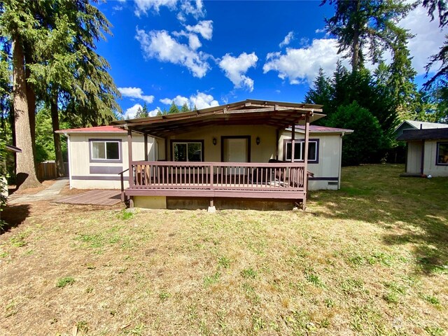 back of property with a yard and a deck