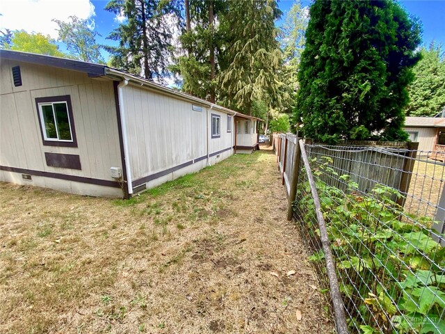 view of home's exterior featuring crawl space, fence, and a lawn