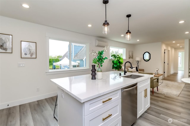 kitchen with a center island with sink, dishwasher, decorative light fixtures, white cabinetry, and a sink