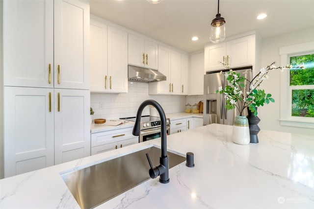 kitchen featuring white cabinets, decorative light fixtures, light stone countertops, stainless steel appliances, and under cabinet range hood