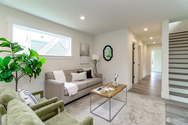 living area with stairs, baseboards, light wood-style flooring, and recessed lighting