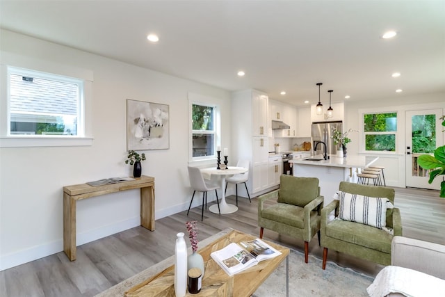 living area featuring recessed lighting, light wood-style flooring, and baseboards