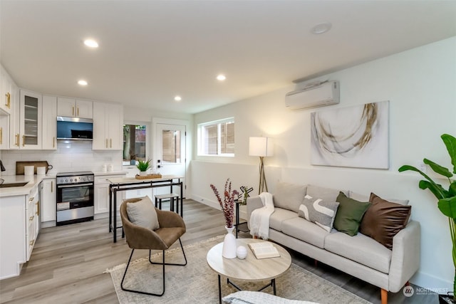 living room with light wood-type flooring, baseboards, recessed lighting, and a wall mounted AC