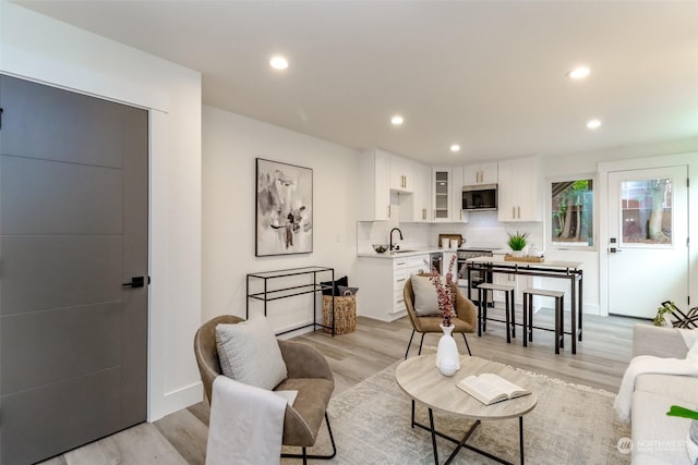 living room with light wood finished floors, baseboards, and recessed lighting