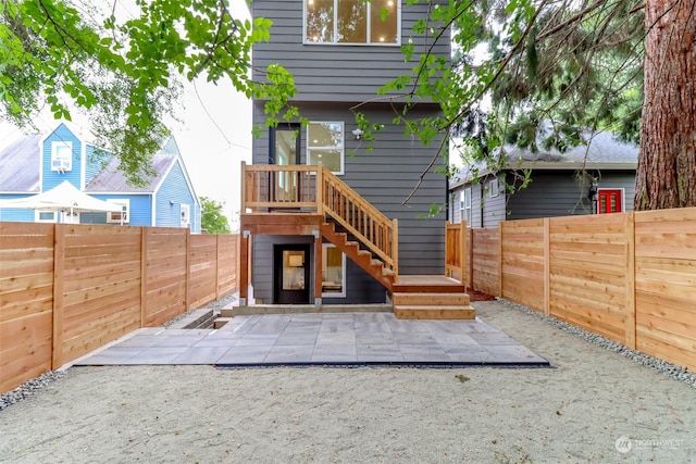 rear view of property with a fenced backyard and a patio