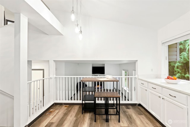 dining area featuring light wood-type flooring and a towering ceiling