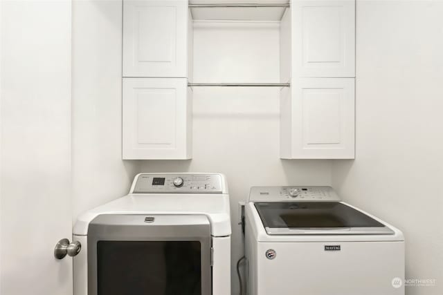 laundry room featuring cabinets and washing machine and dryer