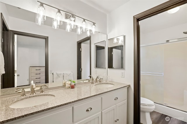 bathroom with vanity, toilet, an enclosed shower, and hardwood / wood-style floors