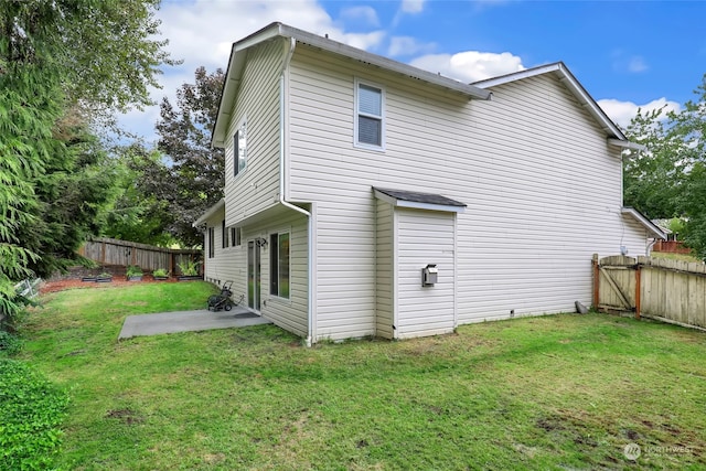 rear view of property with a yard and a patio