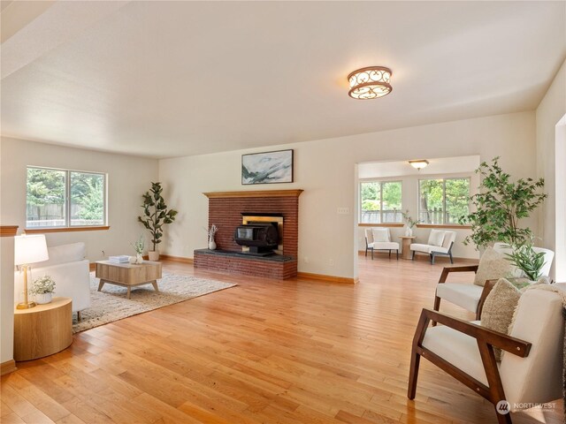 living room featuring light hardwood / wood-style flooring, a wood stove, and a fireplace