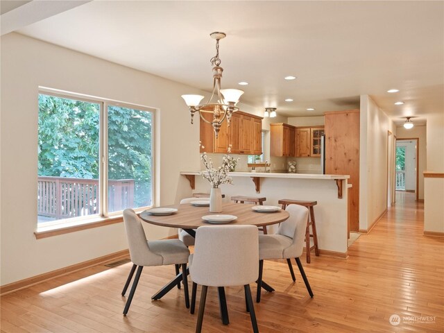 dining area featuring light hardwood / wood-style floors, a chandelier, and a healthy amount of sunlight