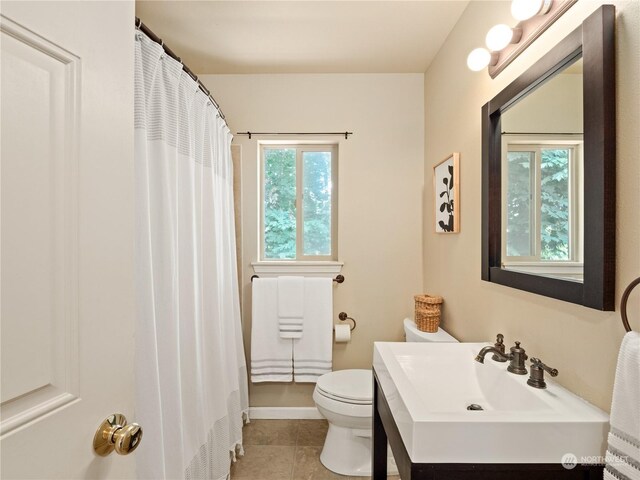 bathroom featuring tile patterned flooring, toilet, and vanity