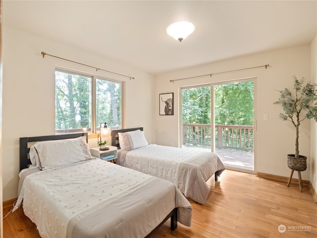 bedroom featuring multiple windows, access to exterior, and light wood-type flooring