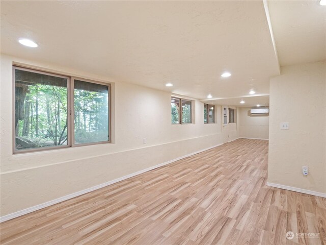 spare room featuring light hardwood / wood-style flooring and a wall unit AC