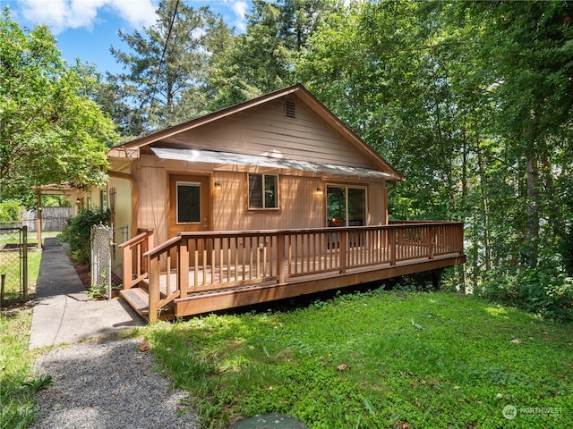 view of front facade with a wooden deck and a front yard