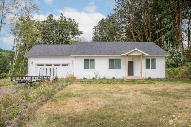 single story home featuring a front lawn and a garage