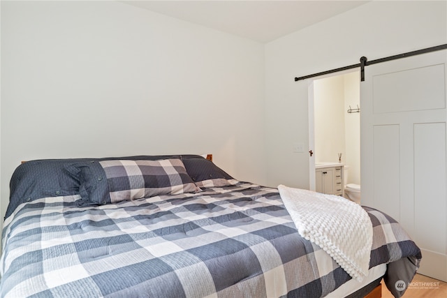 bedroom with a barn door and ensuite bath