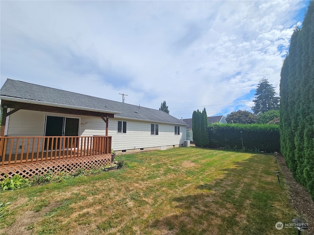 view of yard with central AC unit and a wooden deck