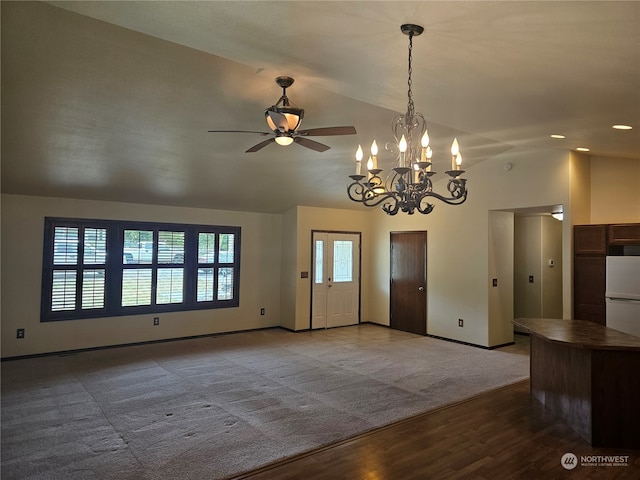 interior space featuring carpet flooring, ceiling fan with notable chandelier, and lofted ceiling