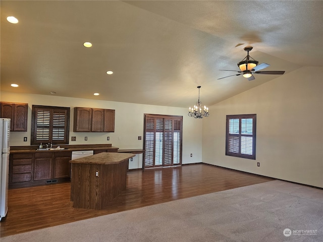 kitchen with dark colored carpet, ceiling fan with notable chandelier, vaulted ceiling, and a center island