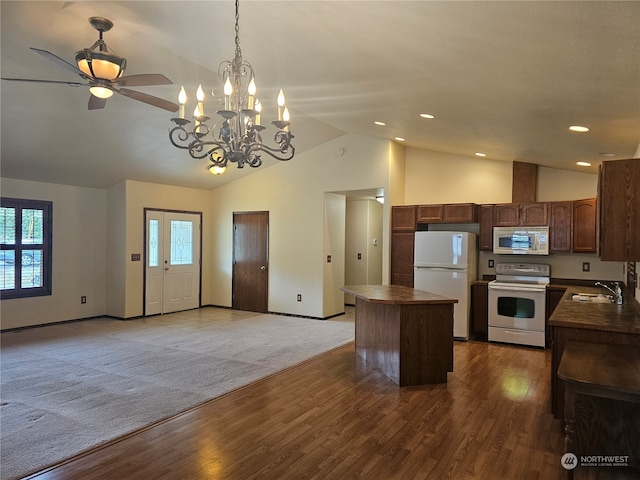 kitchen with decorative light fixtures, sink, ceiling fan with notable chandelier, white appliances, and dark carpet