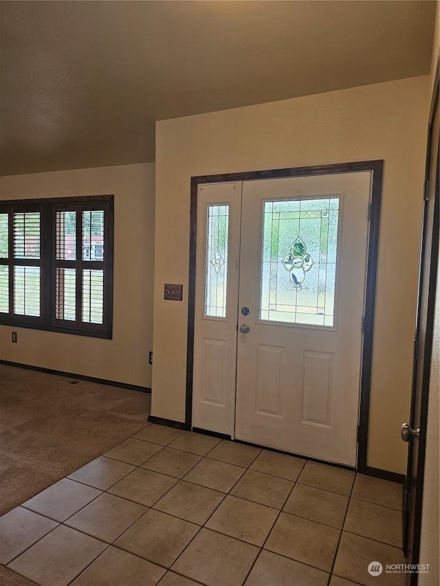 entryway featuring light colored carpet