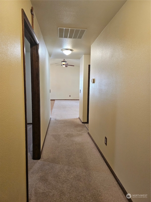 hall featuring light colored carpet