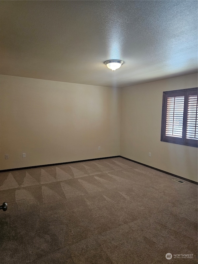 spare room with carpet floors and a textured ceiling