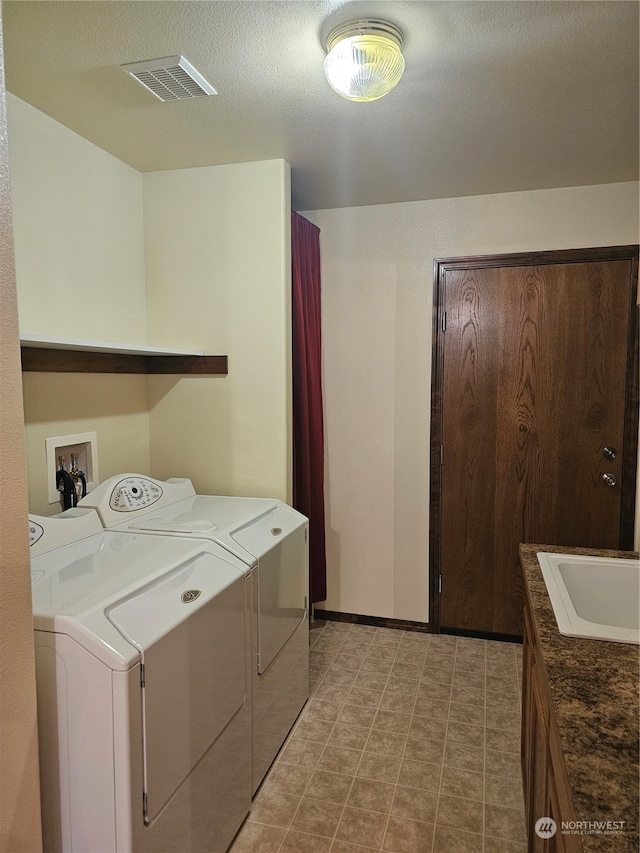 laundry area featuring washer and dryer, light tile patterned floors, sink, and cabinets