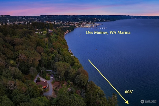 aerial view at dusk featuring a water view