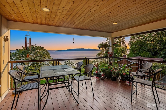 deck at dusk with a water and mountain view