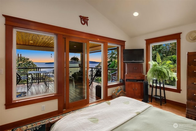 bedroom with hardwood / wood-style floors, access to outside, and lofted ceiling