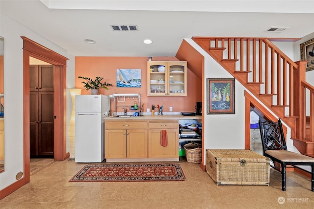 kitchen with white fridge, sink, and light brown cabinets