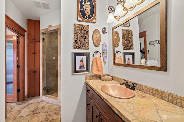 bathroom featuring a shower with door and vanity