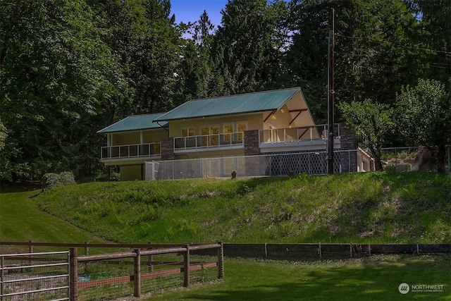 view of front facade with a front lawn and a balcony